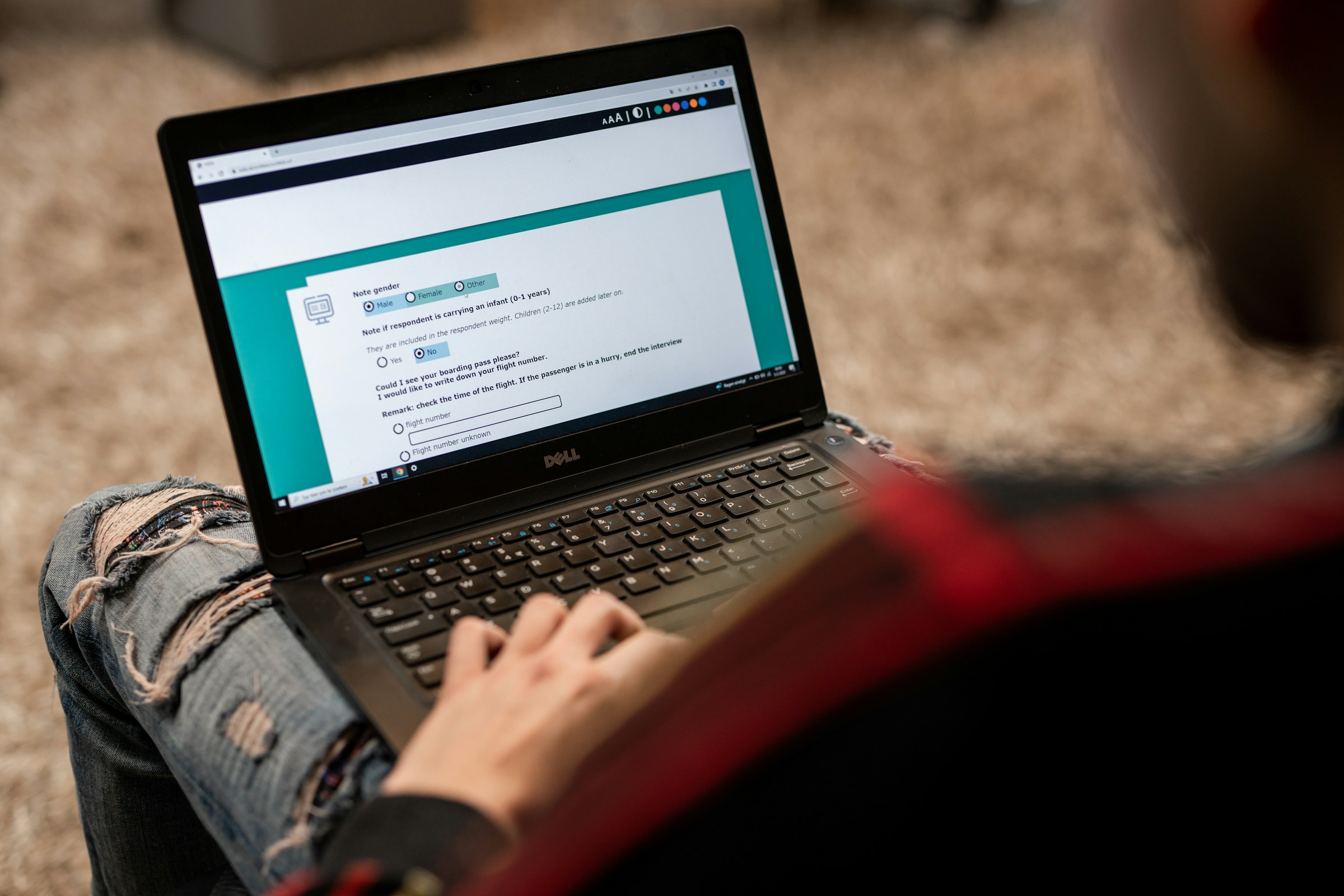 Person completing an online questionnaire on a laptop